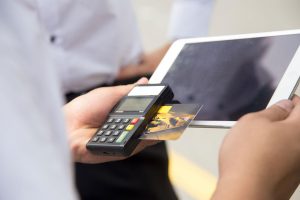 Carput technician processing a credit card payment using the AirPOS By GHL.